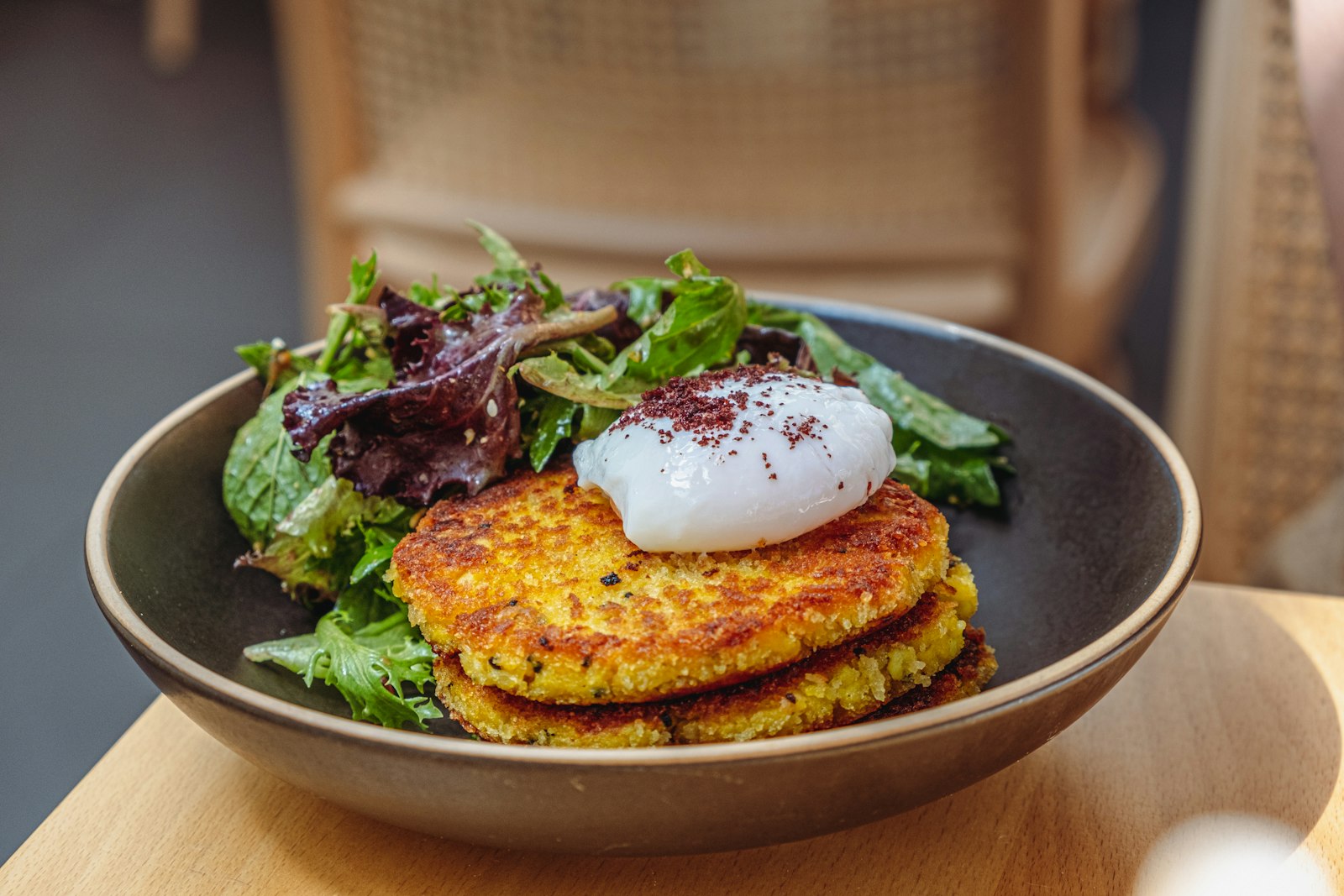 Crispy quinoa cakes topped with a poached egg and greens