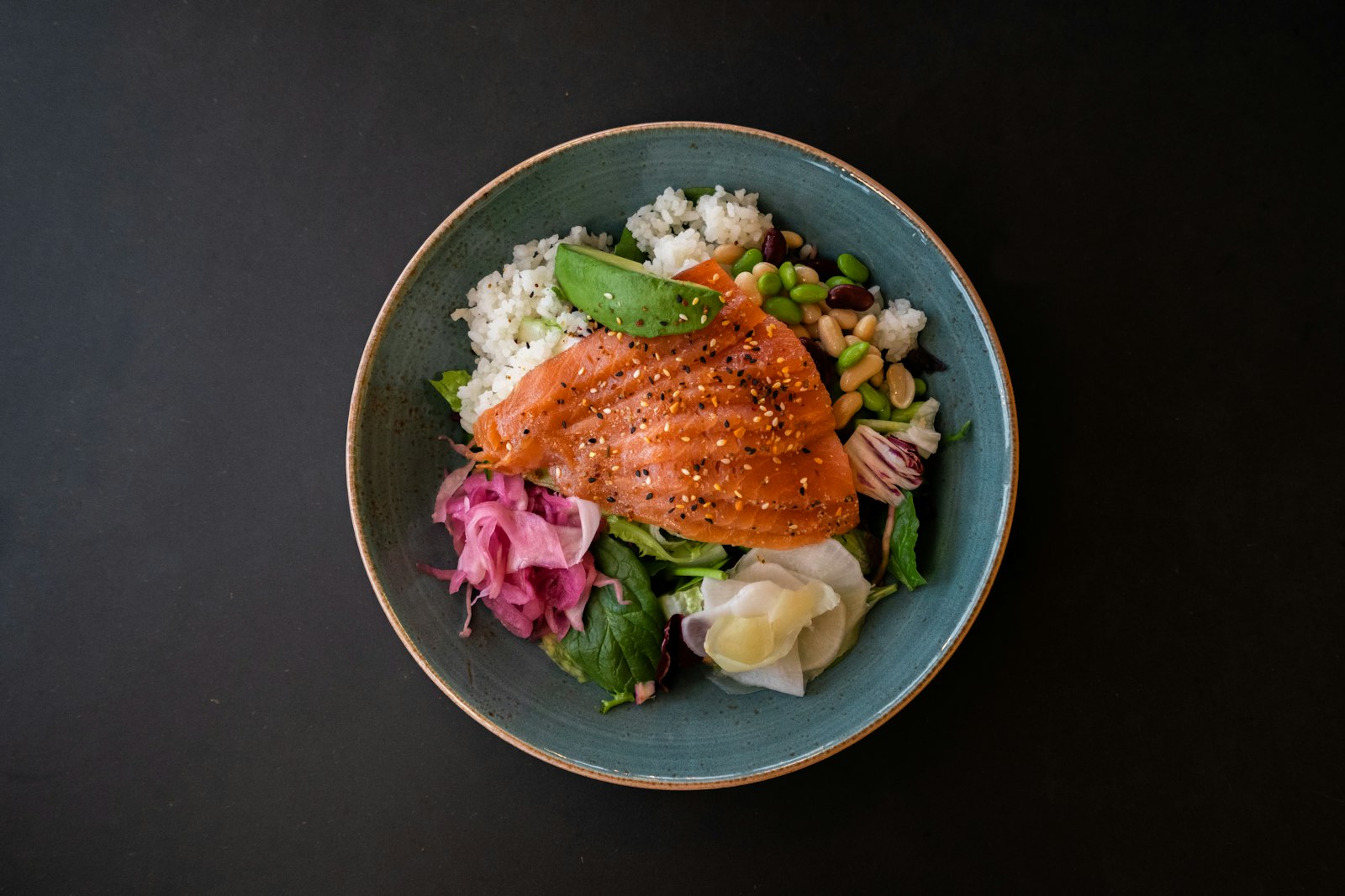 Salmon quinoa bowl with pickled onions and greens
