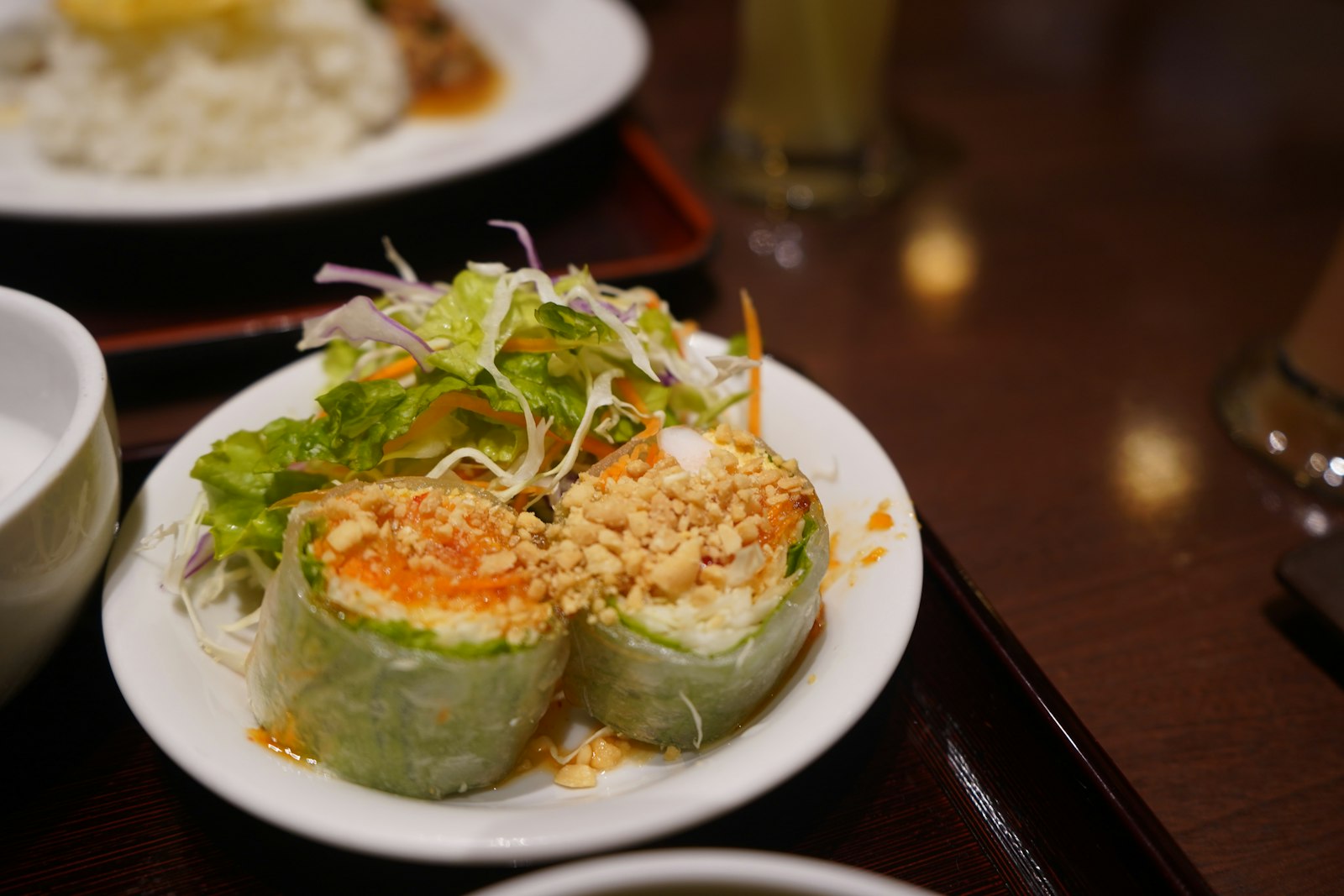 Pan crisped rice paper rolls topped with herbs and salad