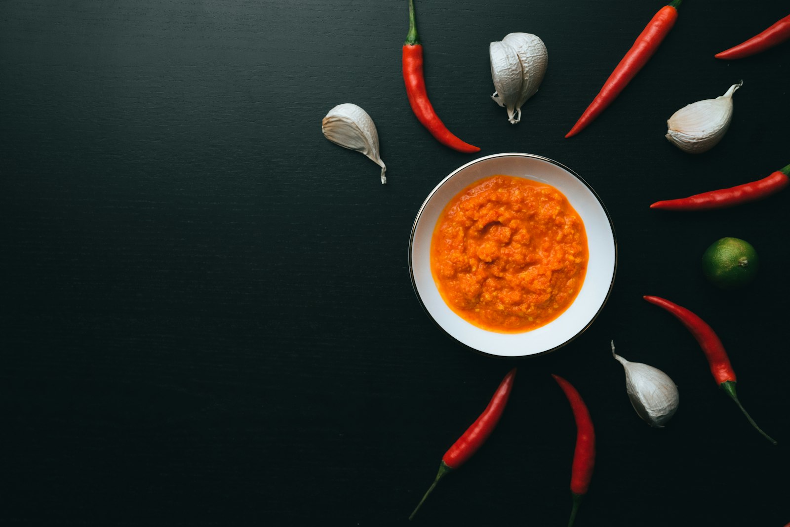 Bowl of chili dipping sauce with fresh chilies and garlic