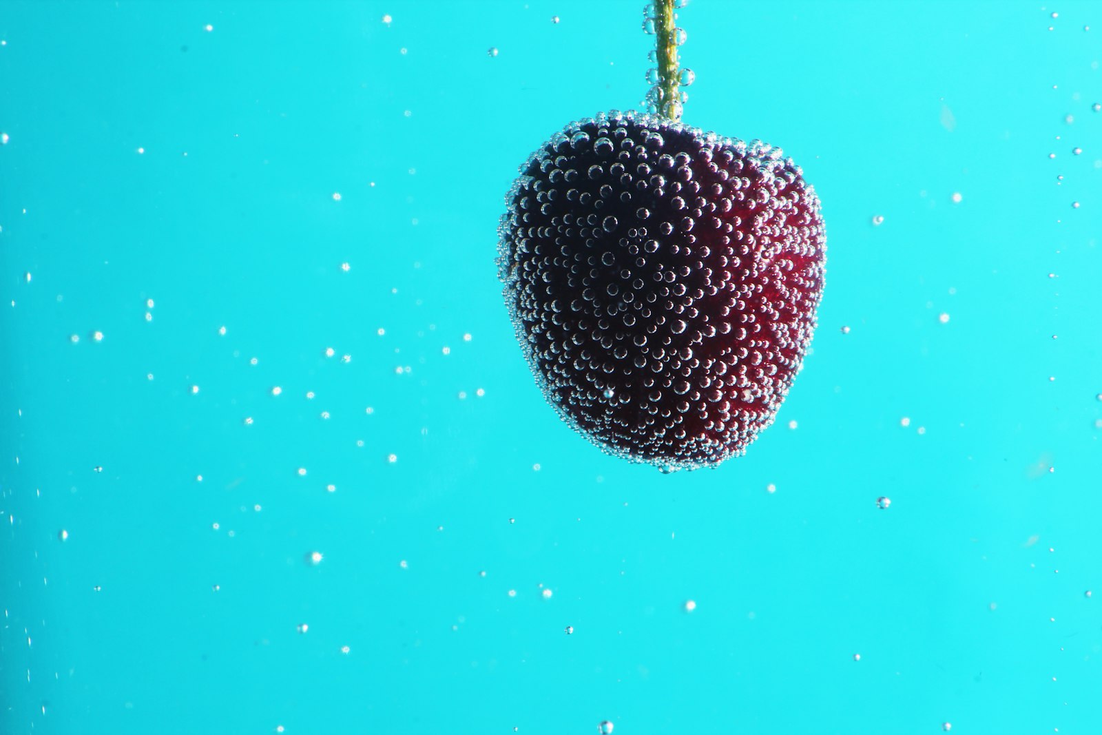 Cherry sinking in bubbly sparkling water