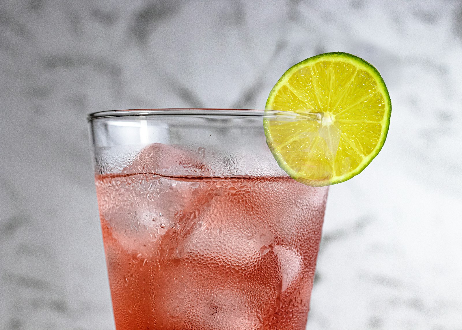 Pink grapefruit soda over ice with a lime wheel