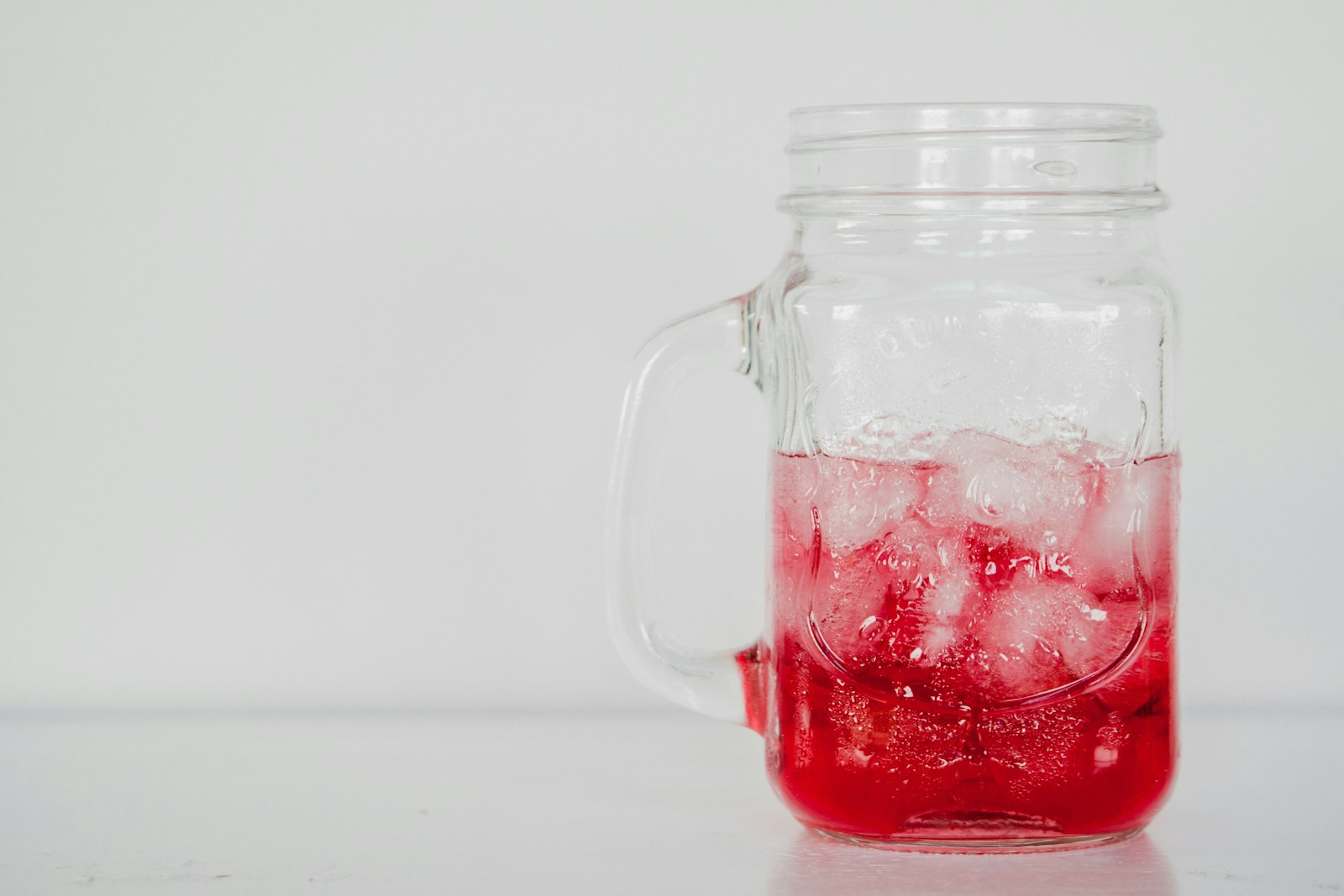 Strawberry syrup soda in a mason jar with ice