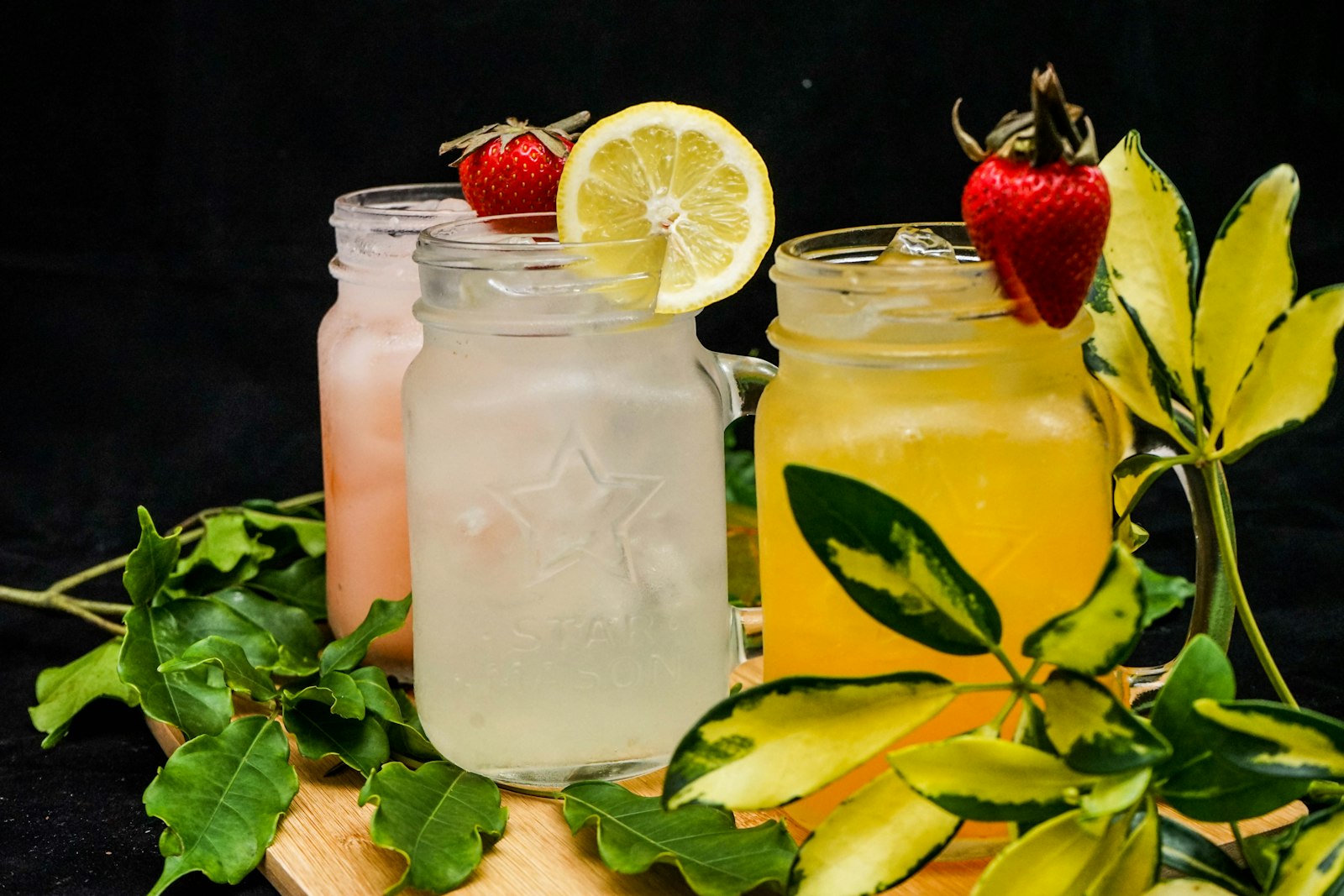 Three fruity sodas with strawberries and lemon
