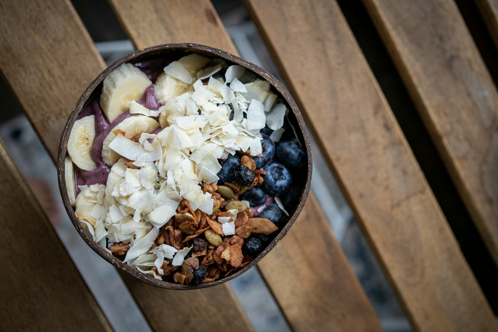 Tropical coconut shell filled with banana, blueberries and nuts
