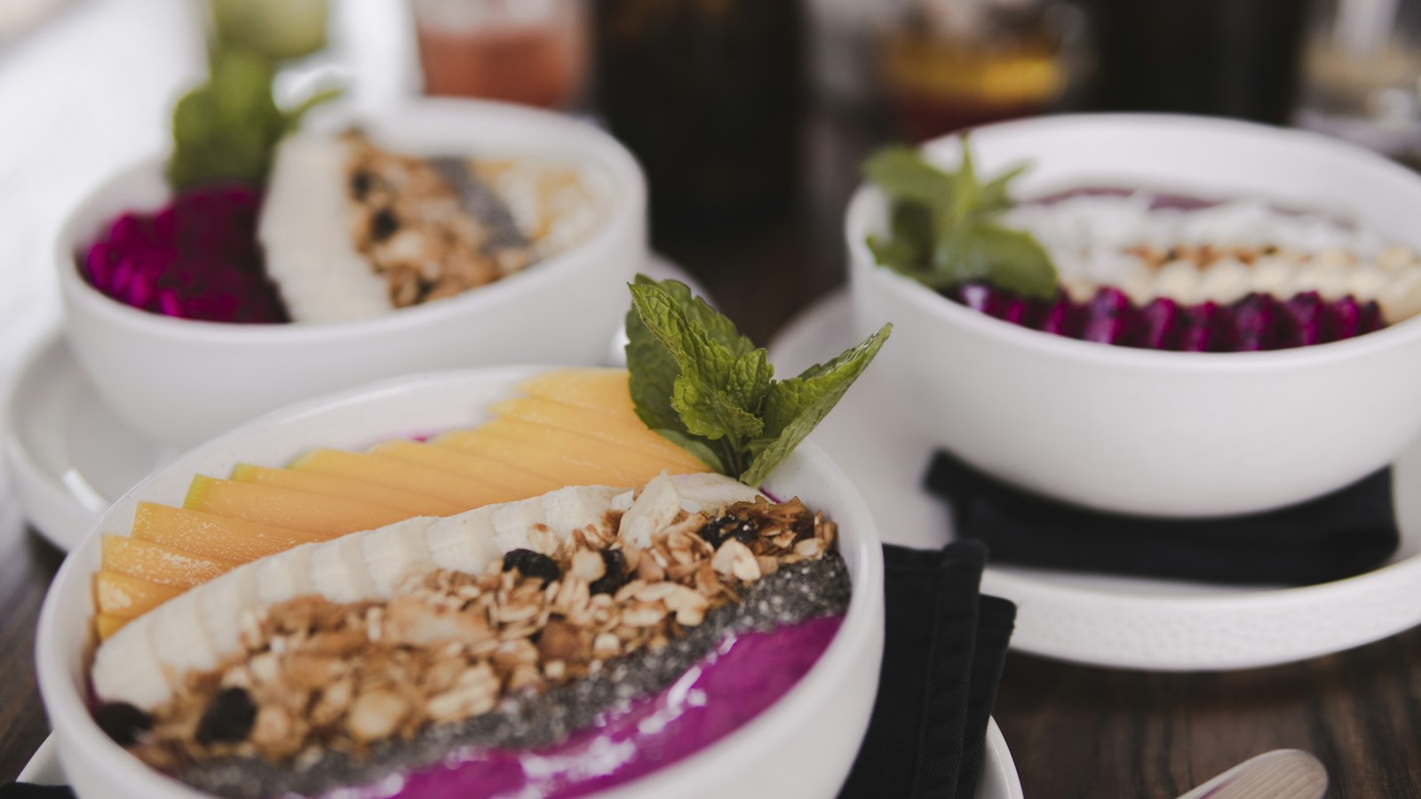 Pink pitaya smoothie bowls with mango slices and mint