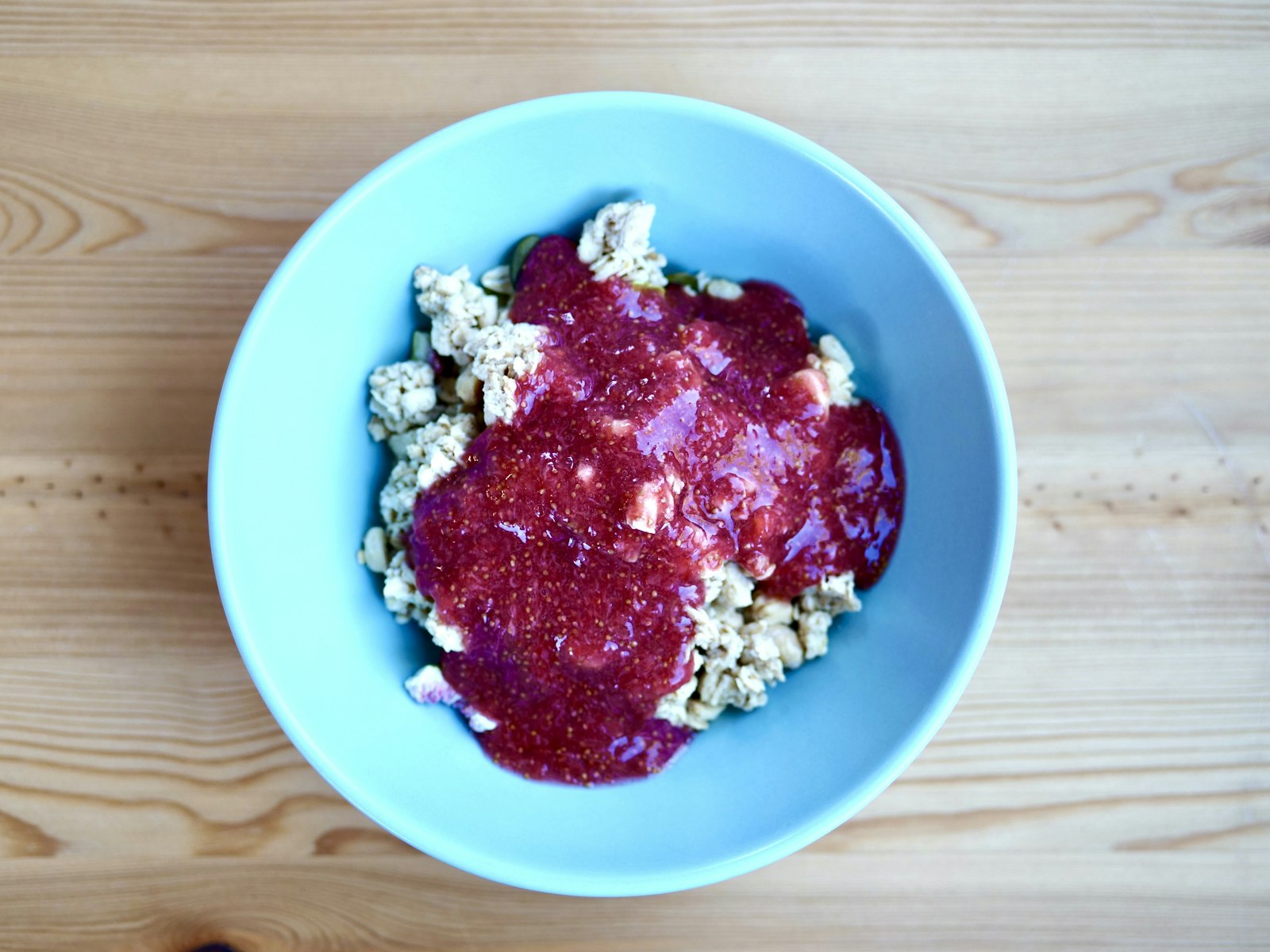 Creamy pink risotto with crumbled cheese in a blue bowl