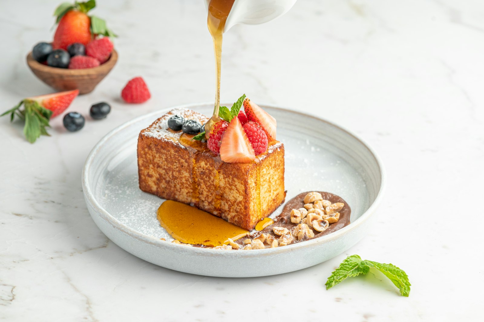Creme brulee French toast with syrup and berries