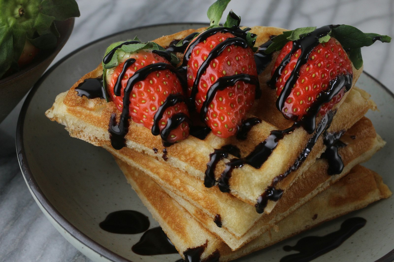 Chocolate drizzled waffles with strawberries
