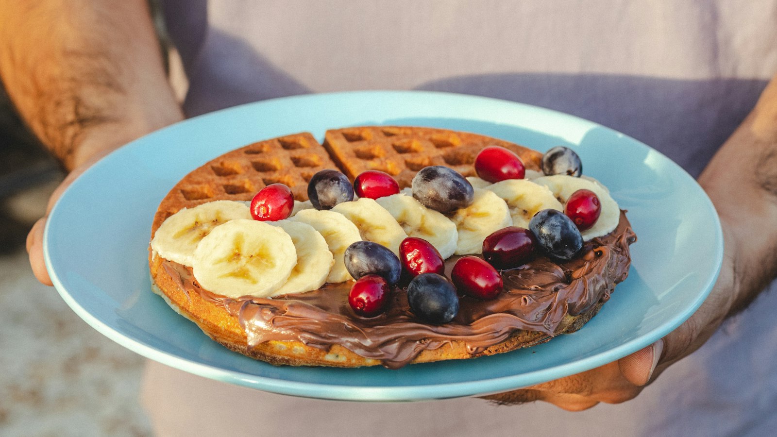 Waffle with hazelnut spread, bananas and berries