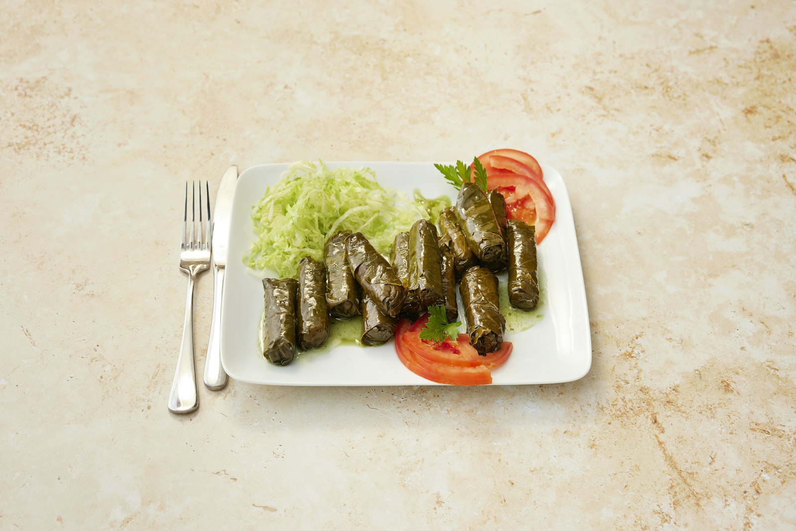 Stuffed grape leaves on a white plate