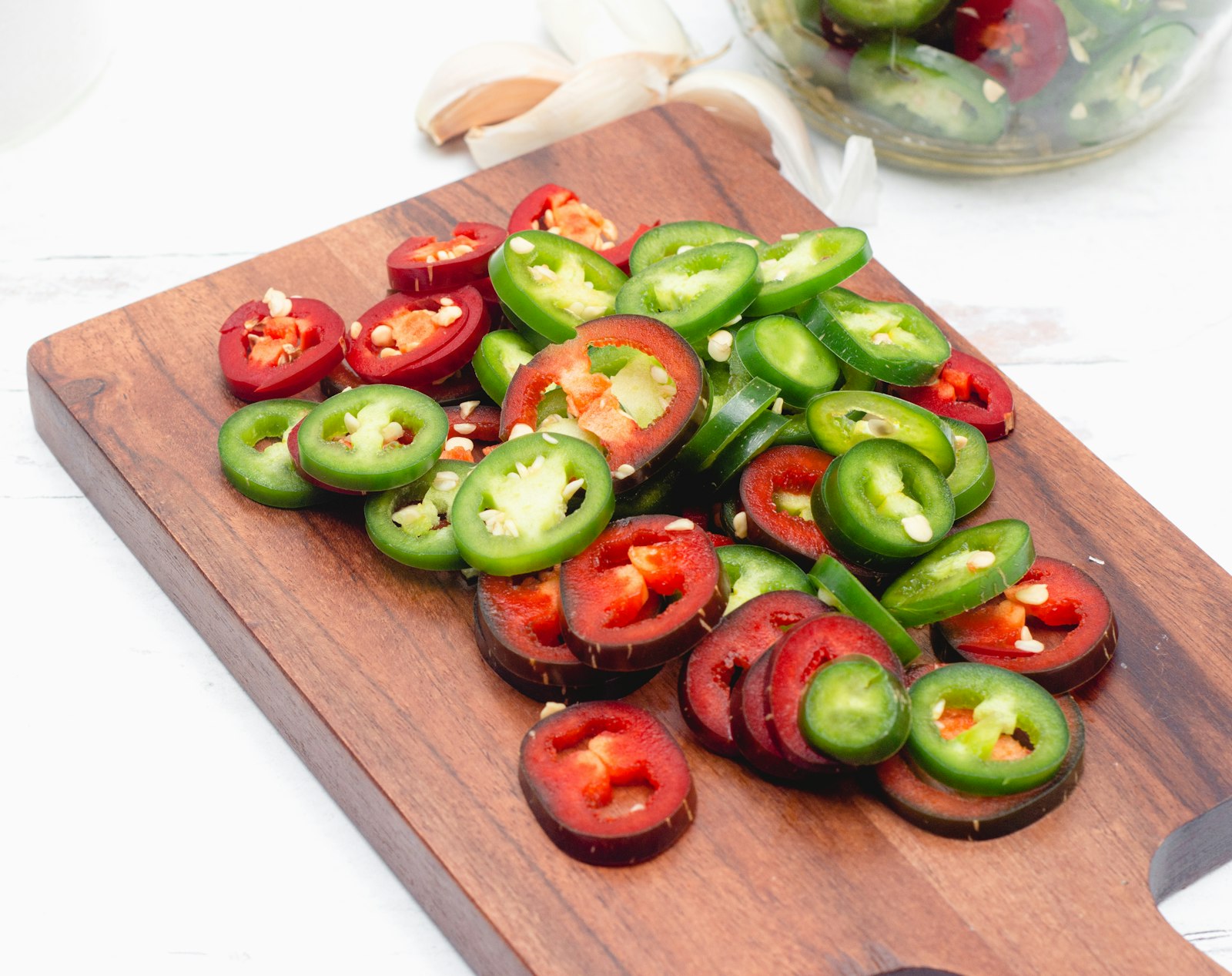 Sliced jalapenos on a wooden board