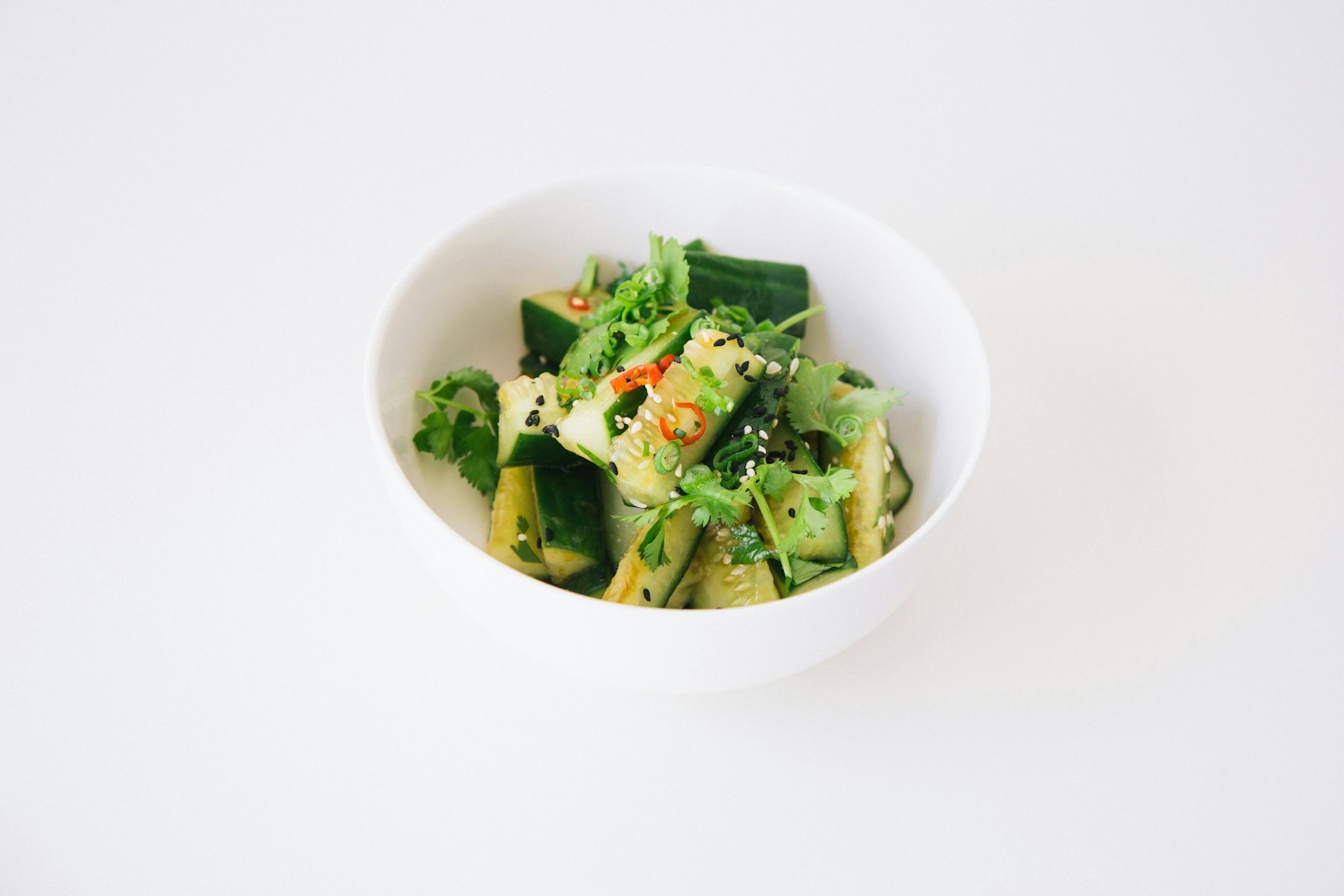Smashed cucumbers with chili in a white bowl