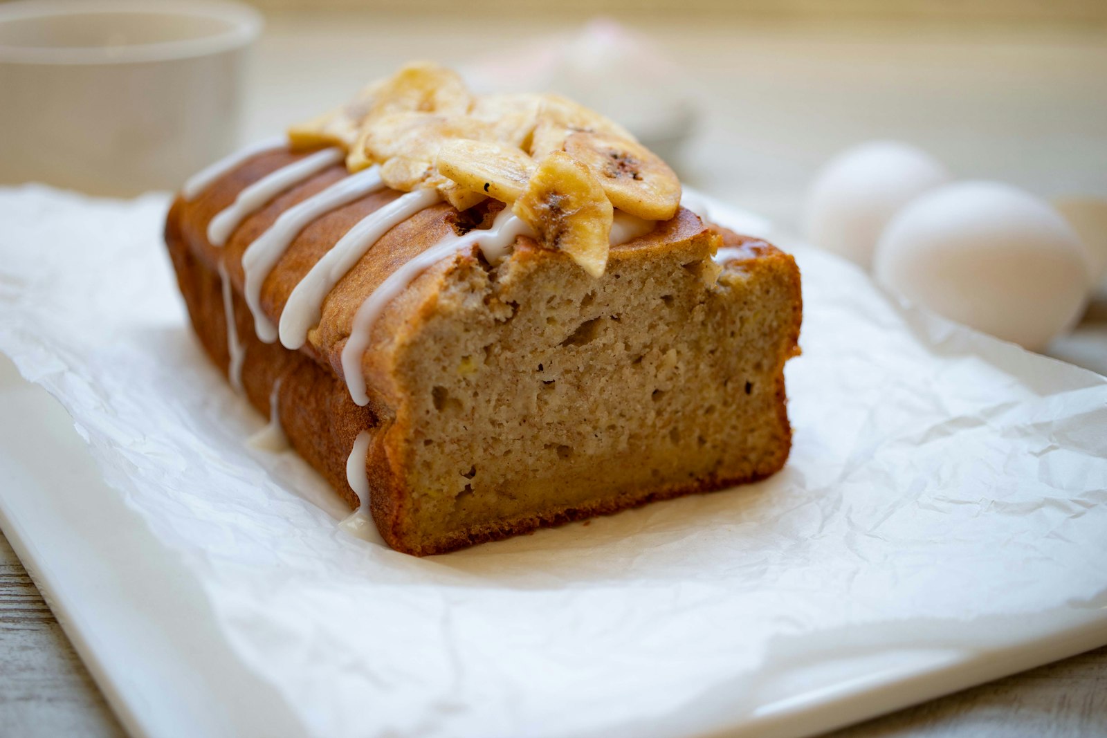 Glazed banana loaf sliced on parchment paper
