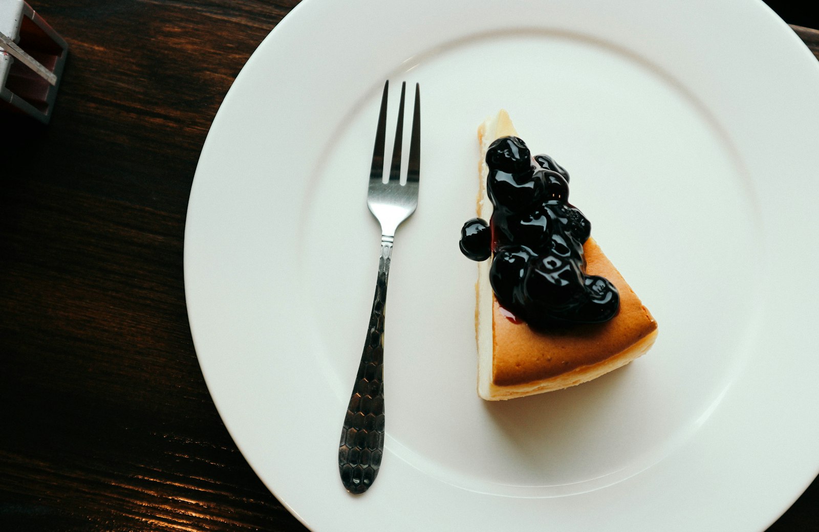 Slice of blueberry cheesecake topped with berries