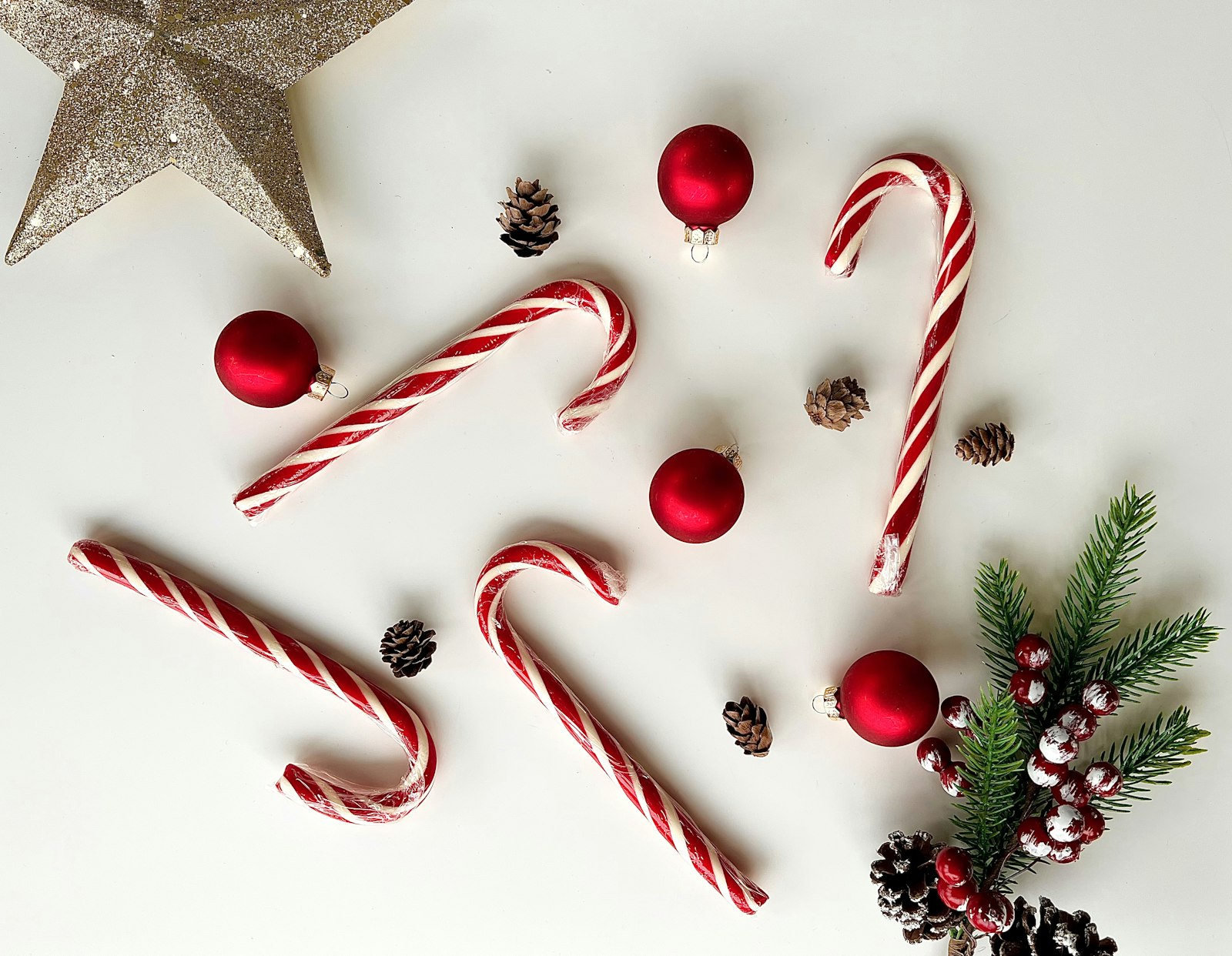 Candy canes and red ornaments on white