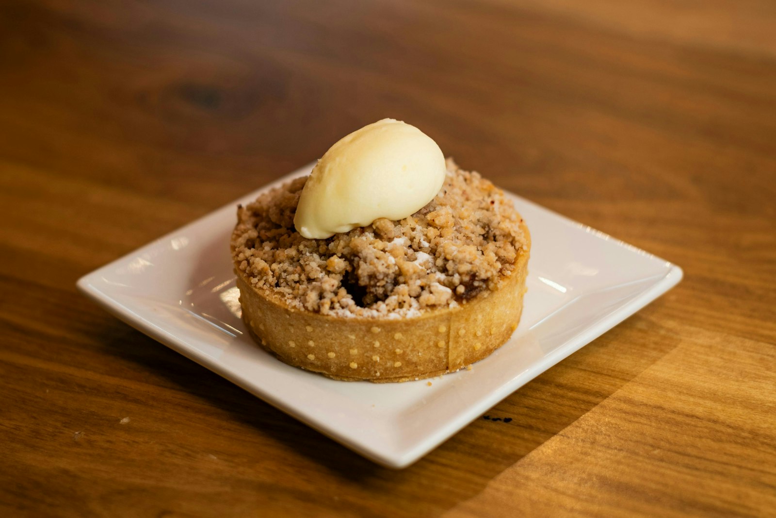 Mini apple crumble tart topped with ice cream