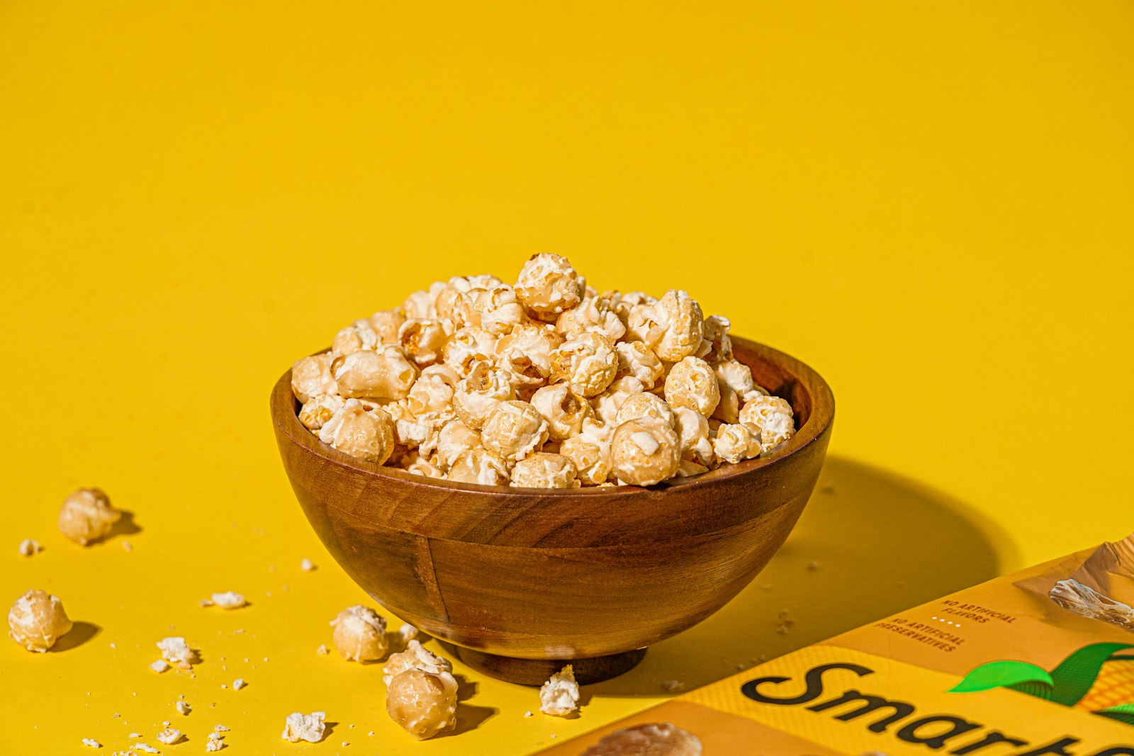 Bowl of crunchy caramel corn on a yellow background