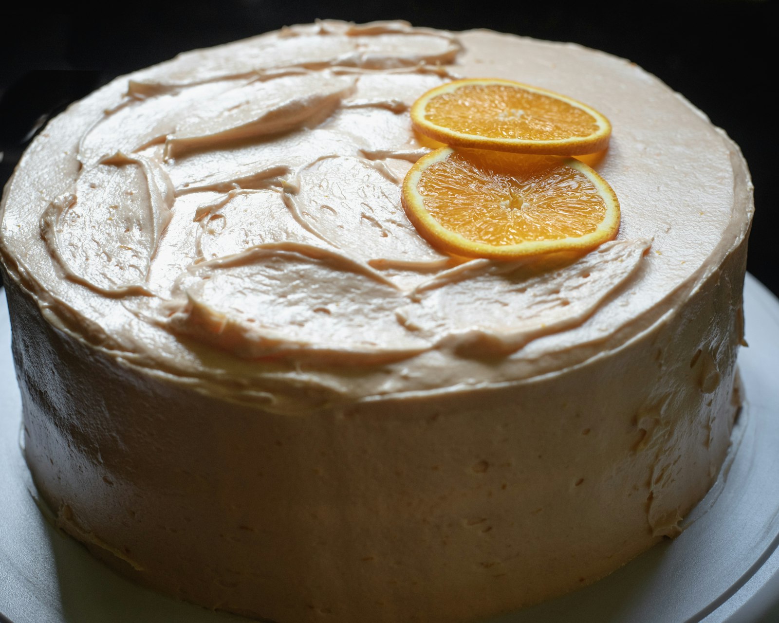 Frosted citrus layer cake decorated with orange slices