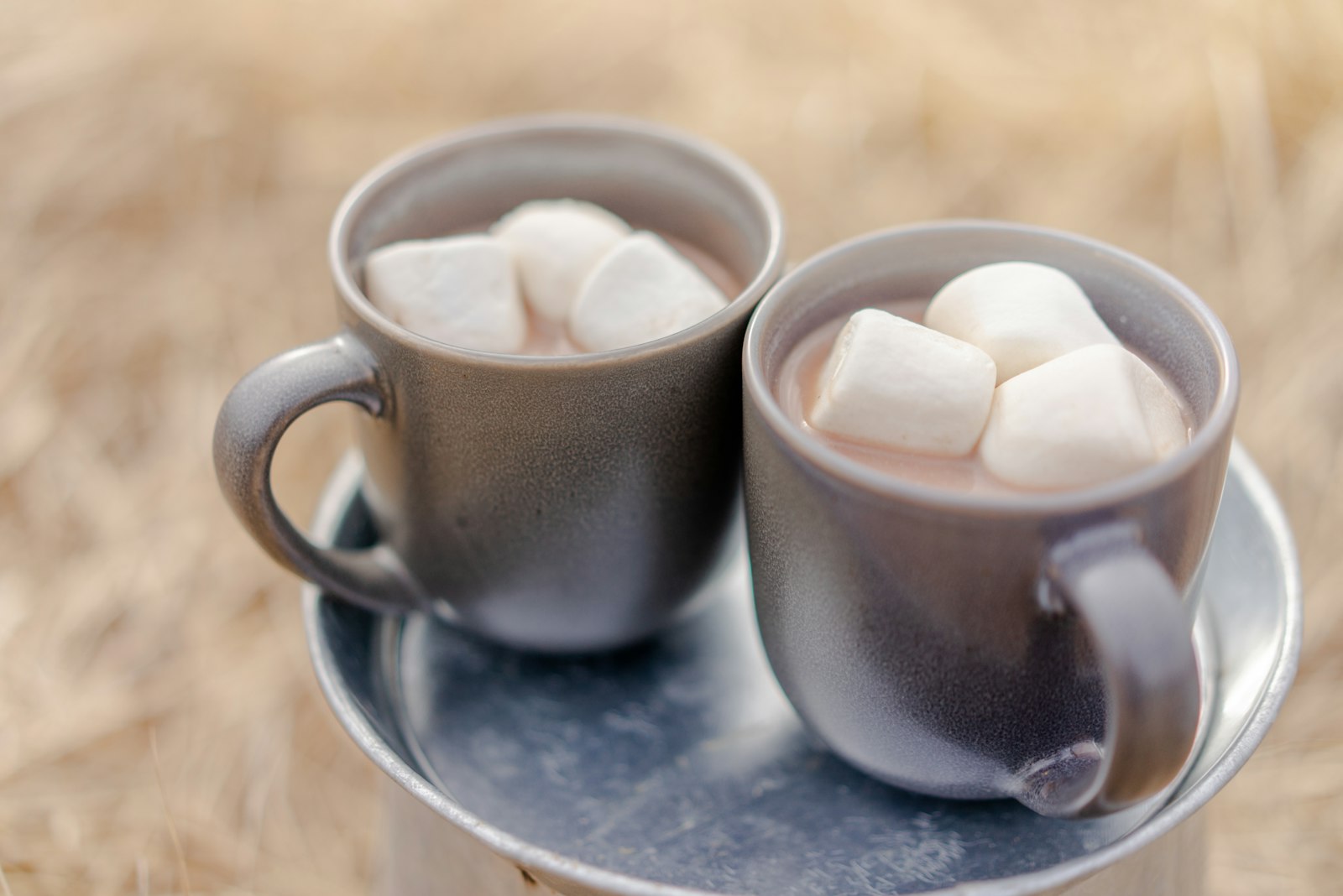 Two mugs of hot cocoa topped with marshmallows