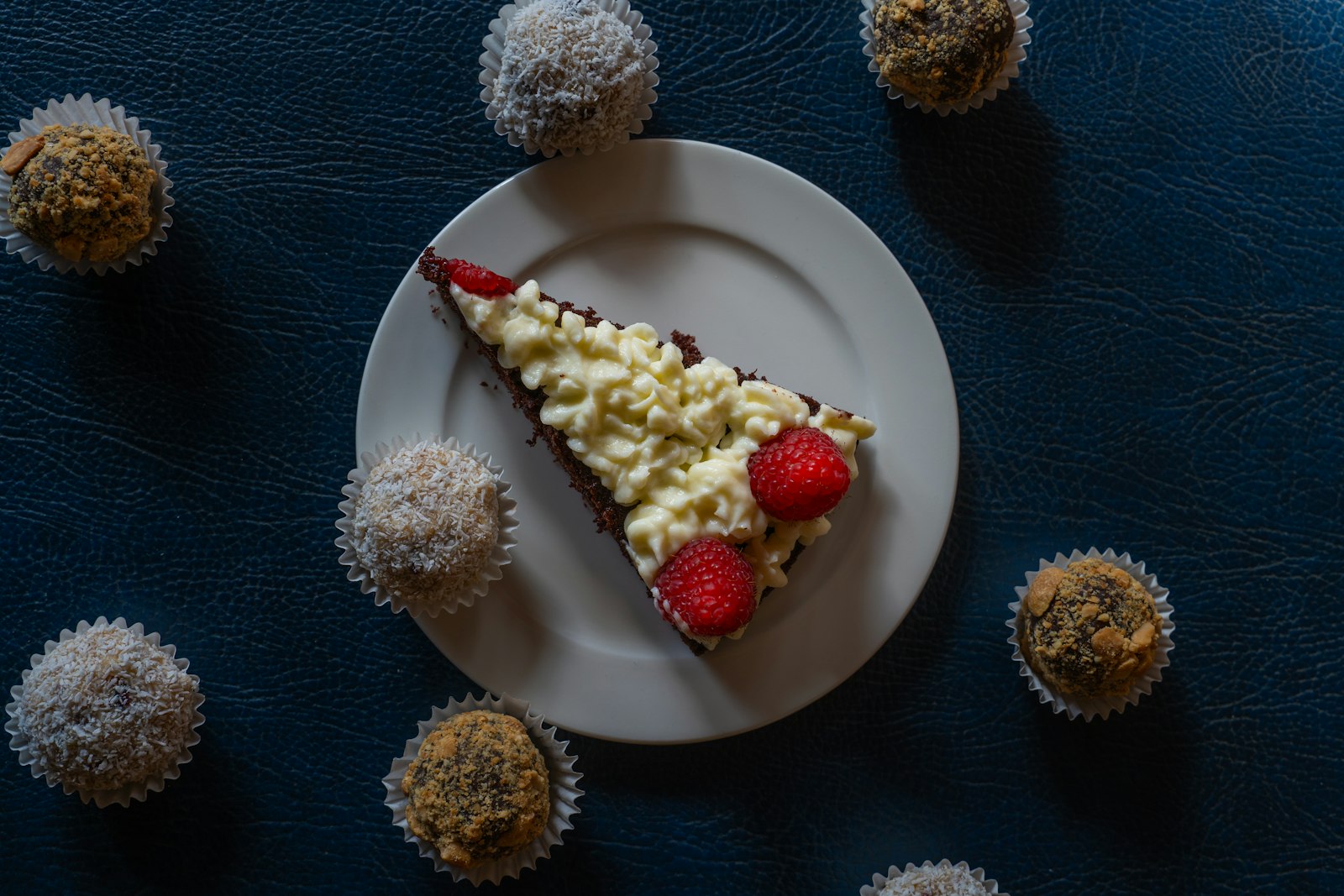 Slice of coconut cake on a dark plate