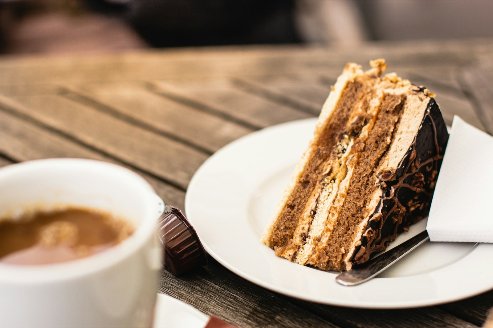 Layered espresso coffee cake slice beside a cup of coffee
