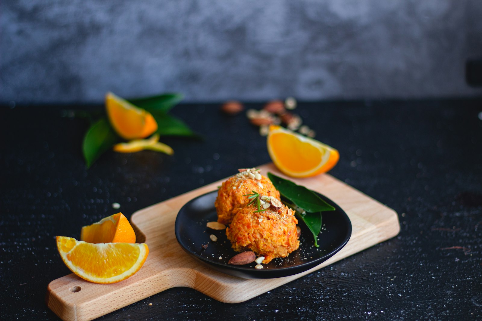 Carrot halwa served on a dark plate with orange slices