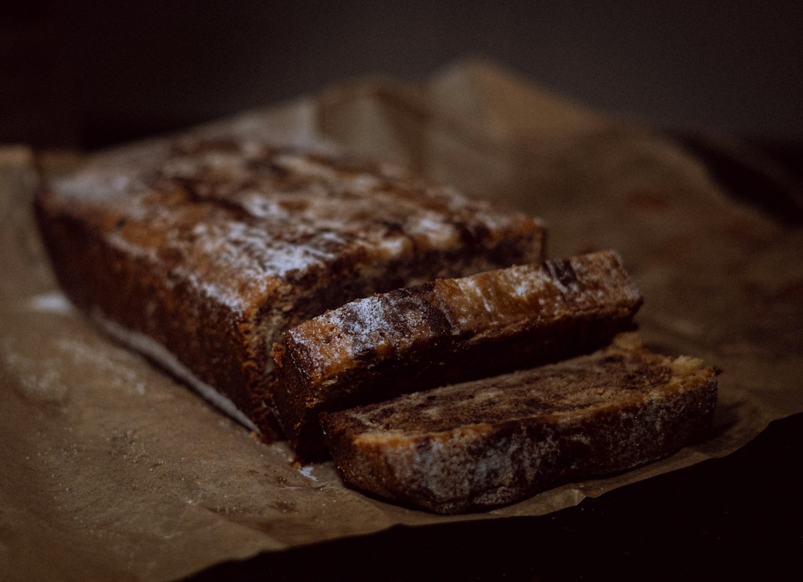 Dark sticky spice loaf sliced on a board