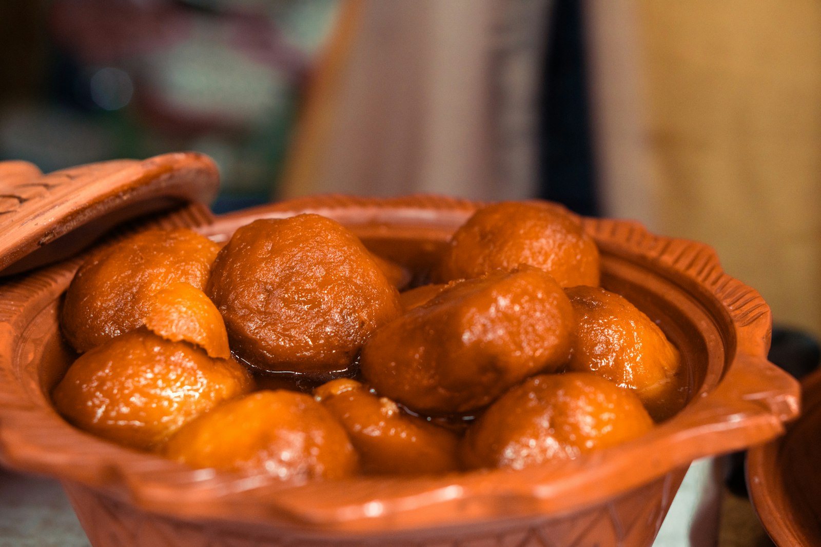 Gulab jamun soaked in syrup in a clay bowl