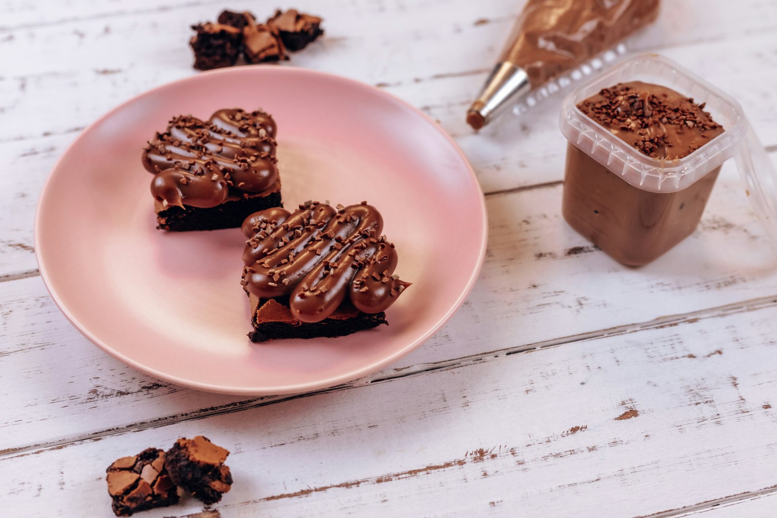 Brownie drizzled with hazelnut spread on a pink plate
