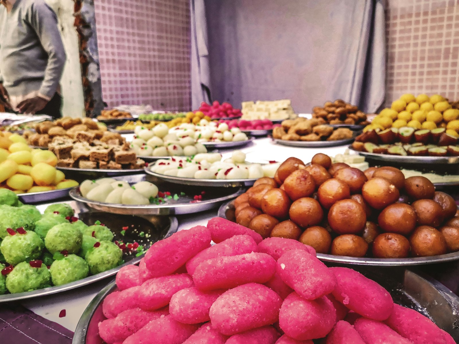 Market stall piled with ladoo and colorful Diwali sweets