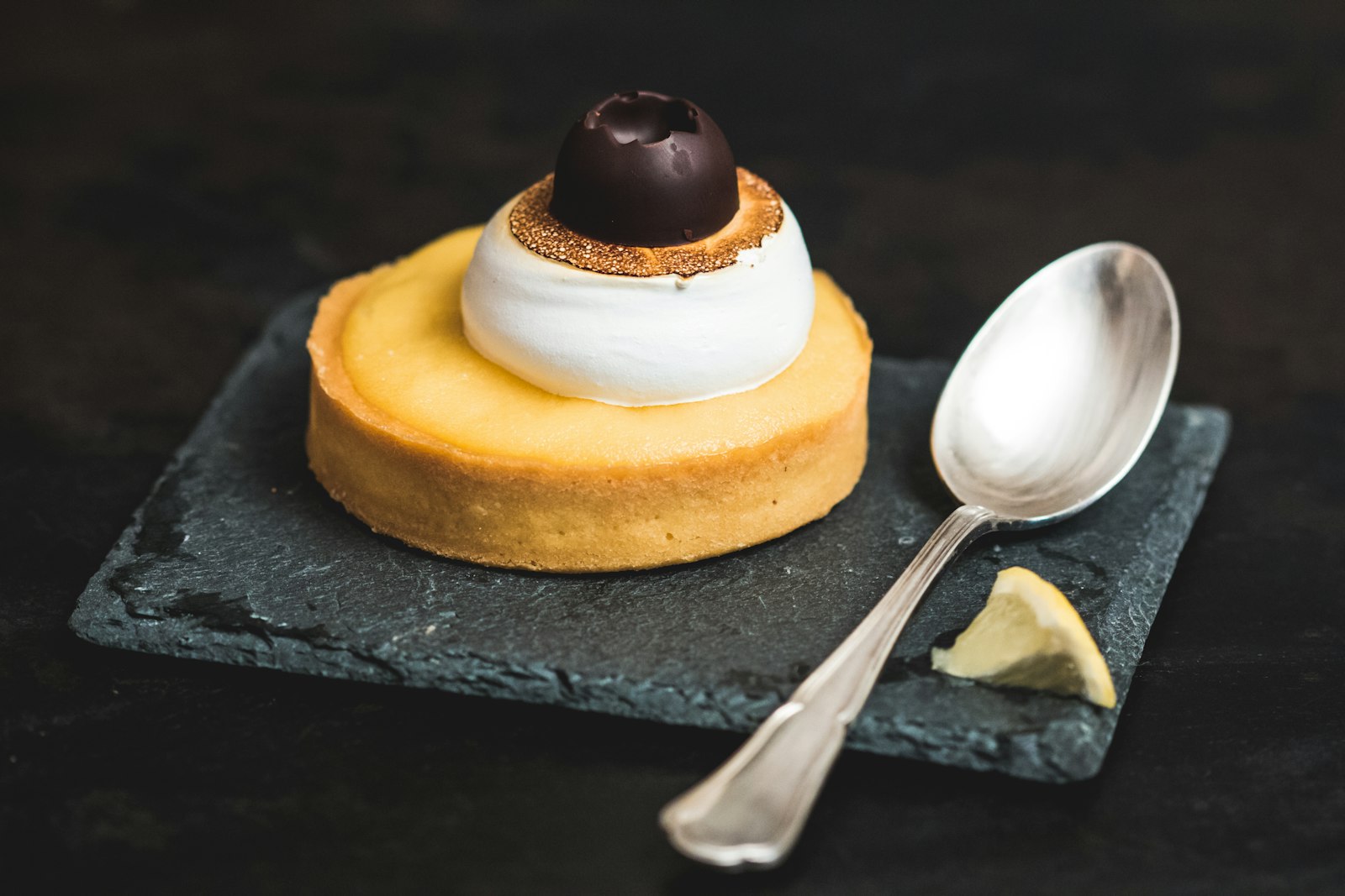 Mini lime tartlet with whipped cream on a slate board