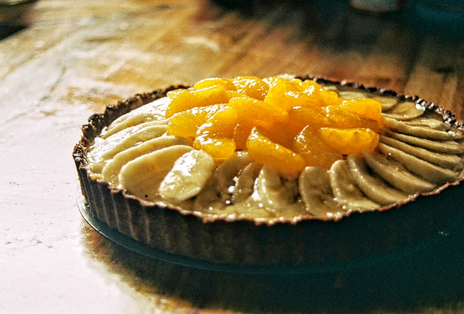 Mandarin orange tart with fruit arranged on custard