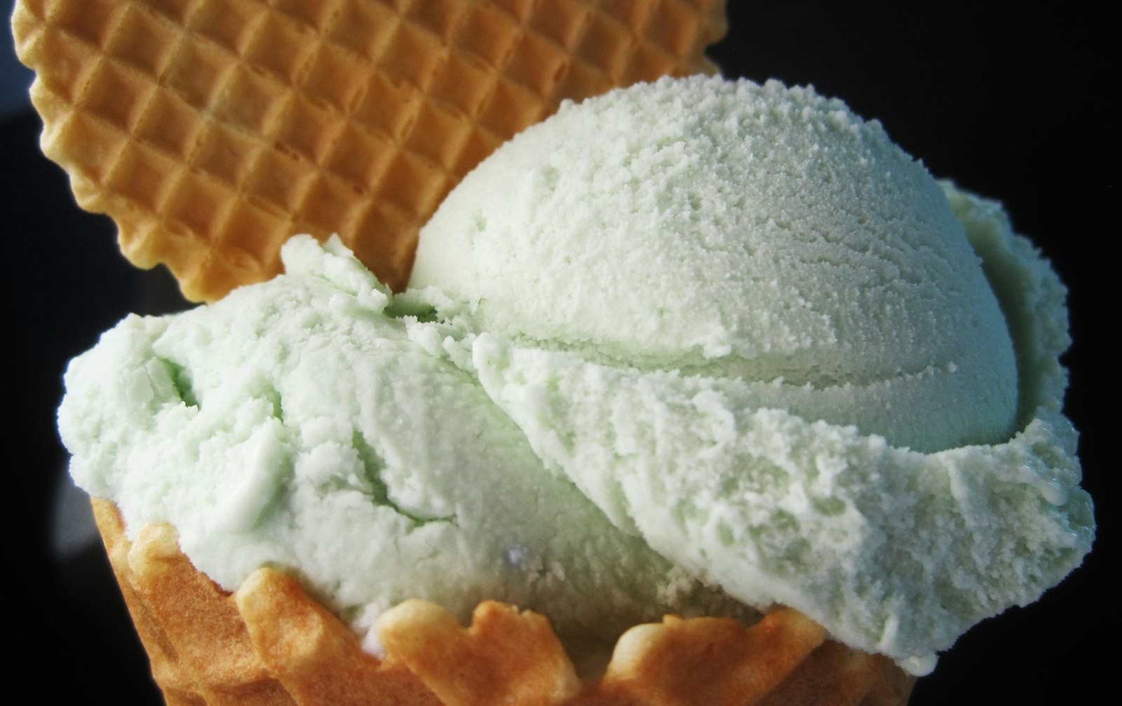 Scoop of pale green mint ice cream with a wafer