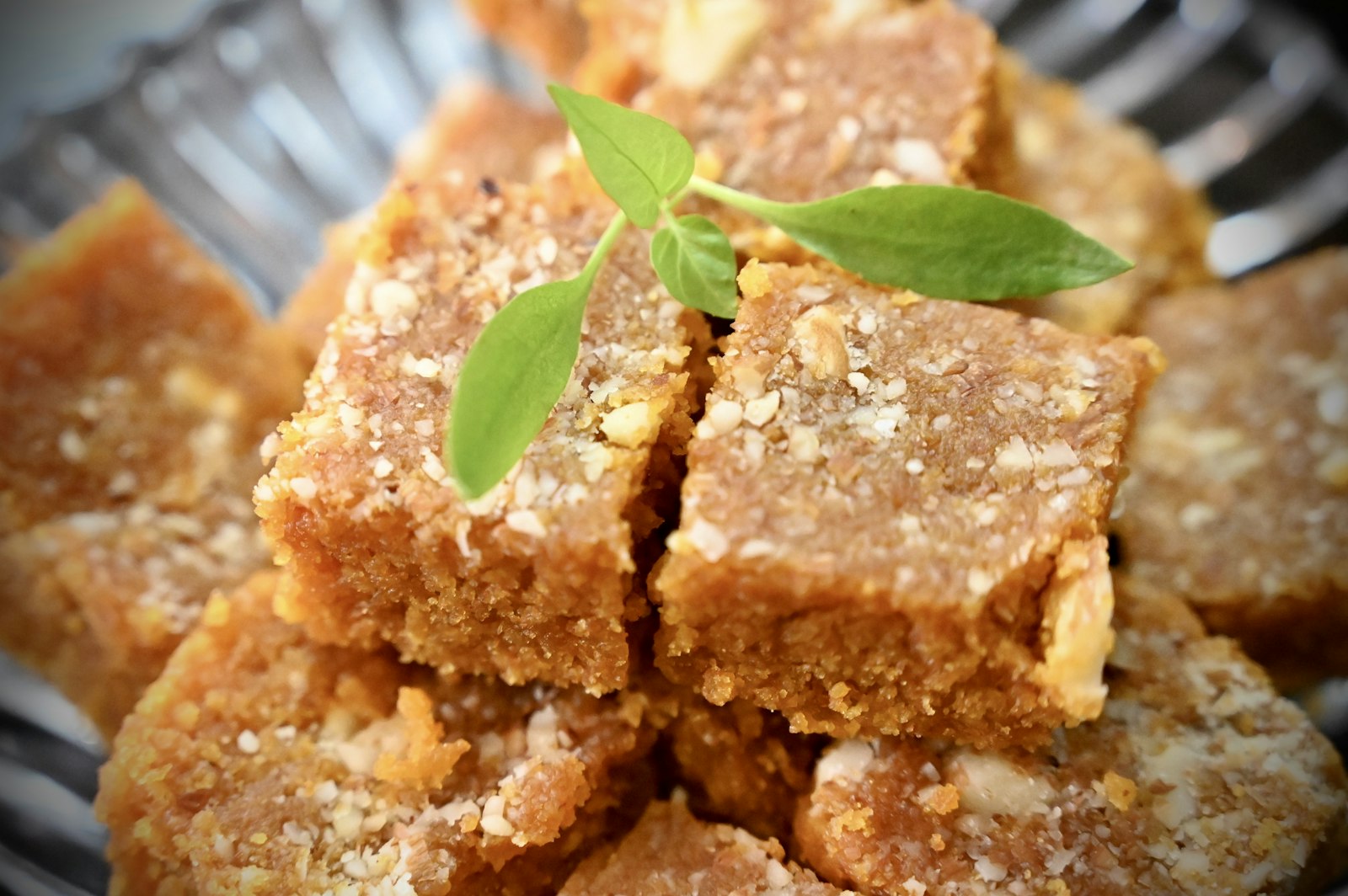 Squares of golden mysore pak with a green leaf
