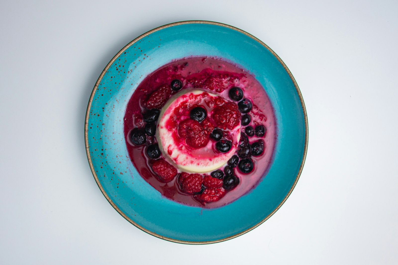 Berry panna cotta in a blue bowl, one of the prettiest no bake desserts