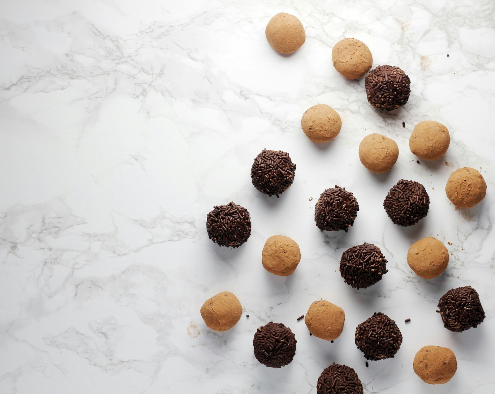 Peanut butter balls and chocolate truffles on marble