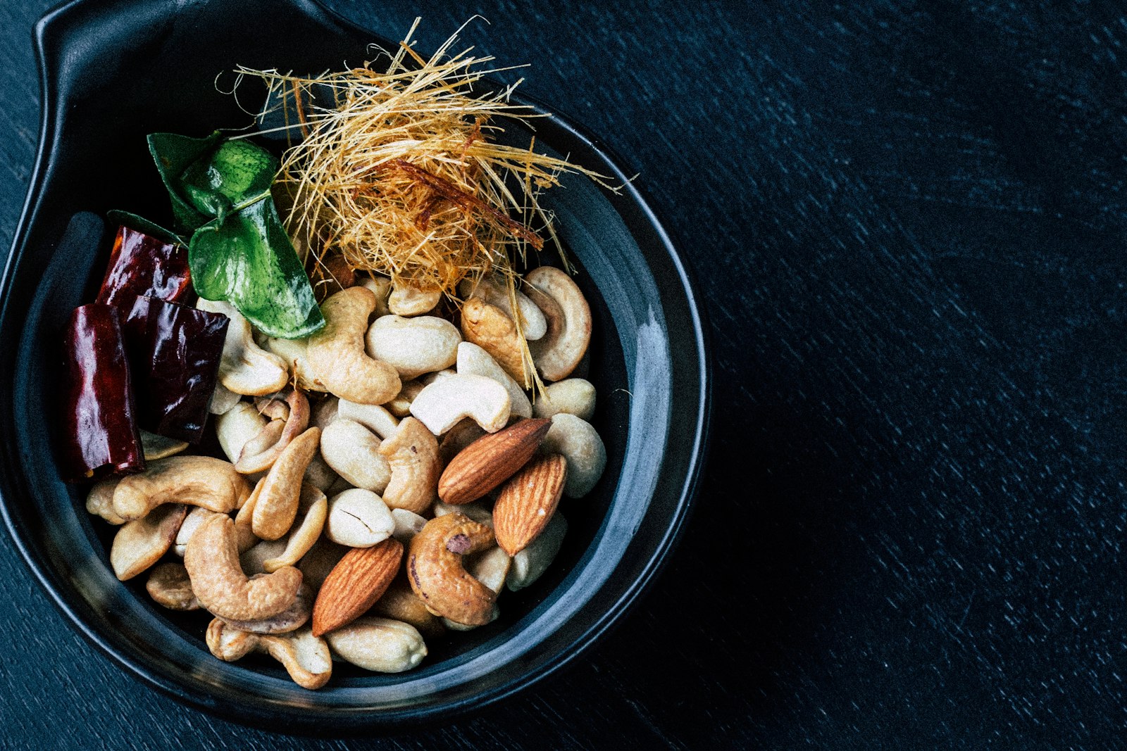 Bowl of roasted mixed nuts with rosemary