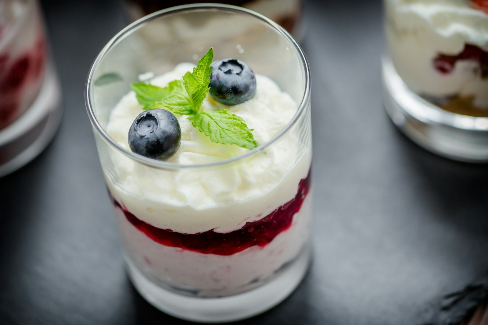 Berry parfait with cream and blueberries in a glass