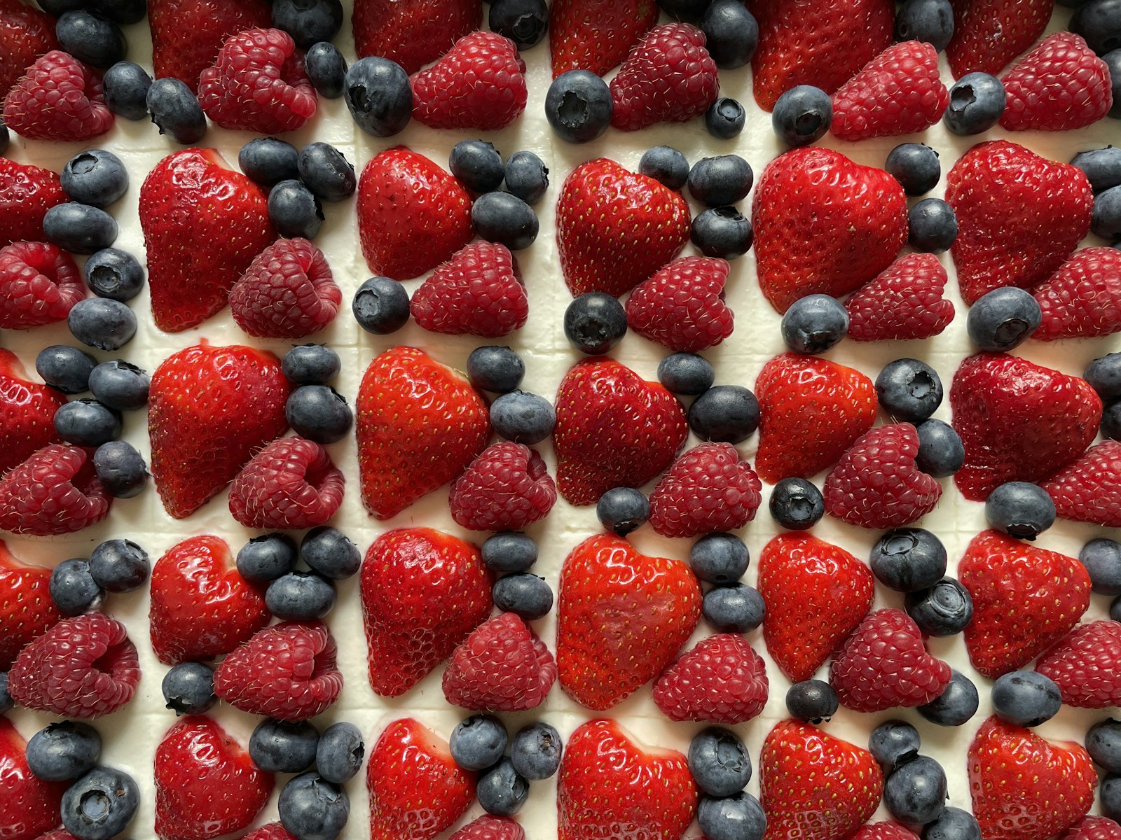 Sheet dessert topped with fresh strawberries and blueberries