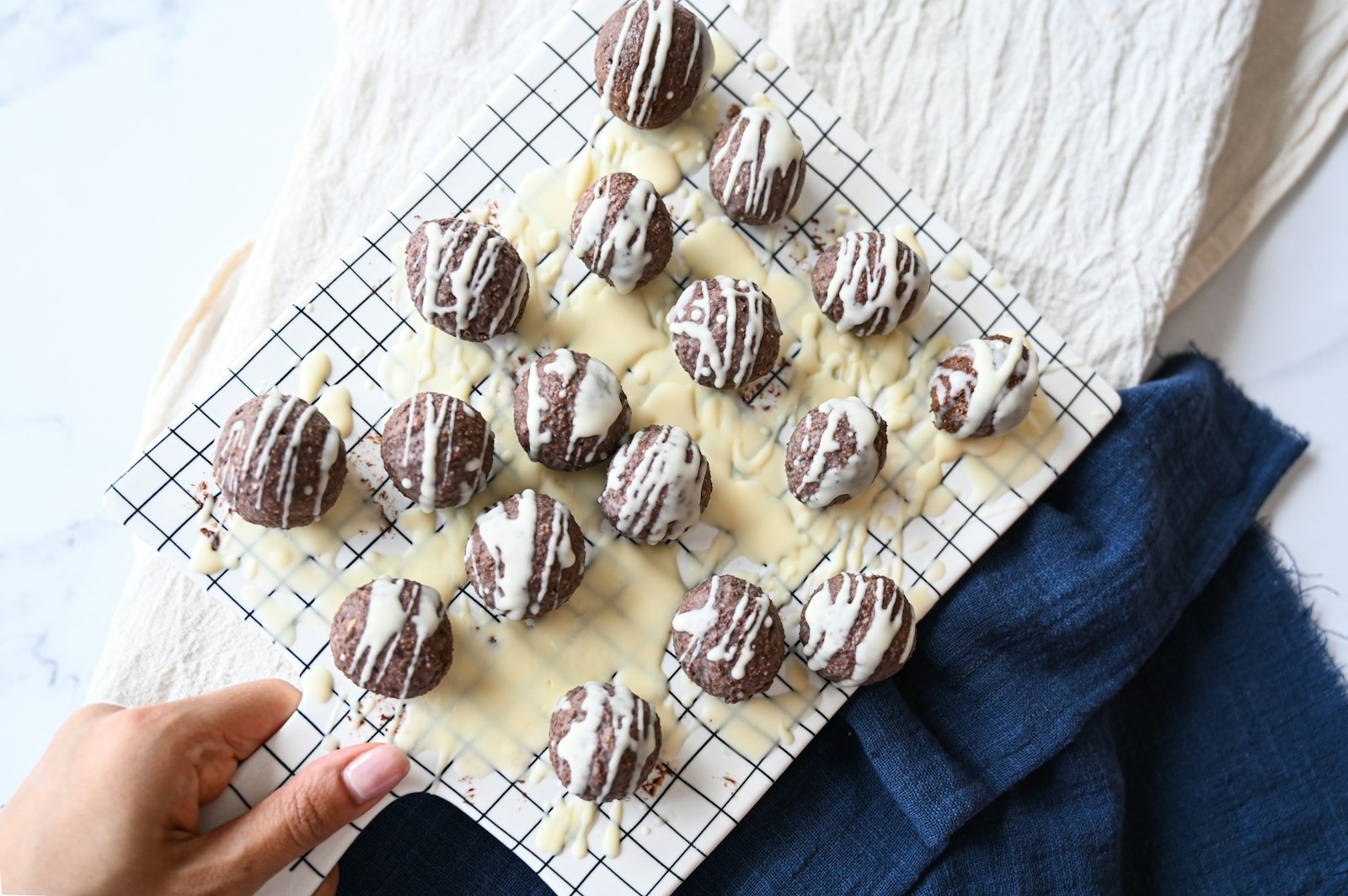 Chocolate drizzled protein balls on a rack