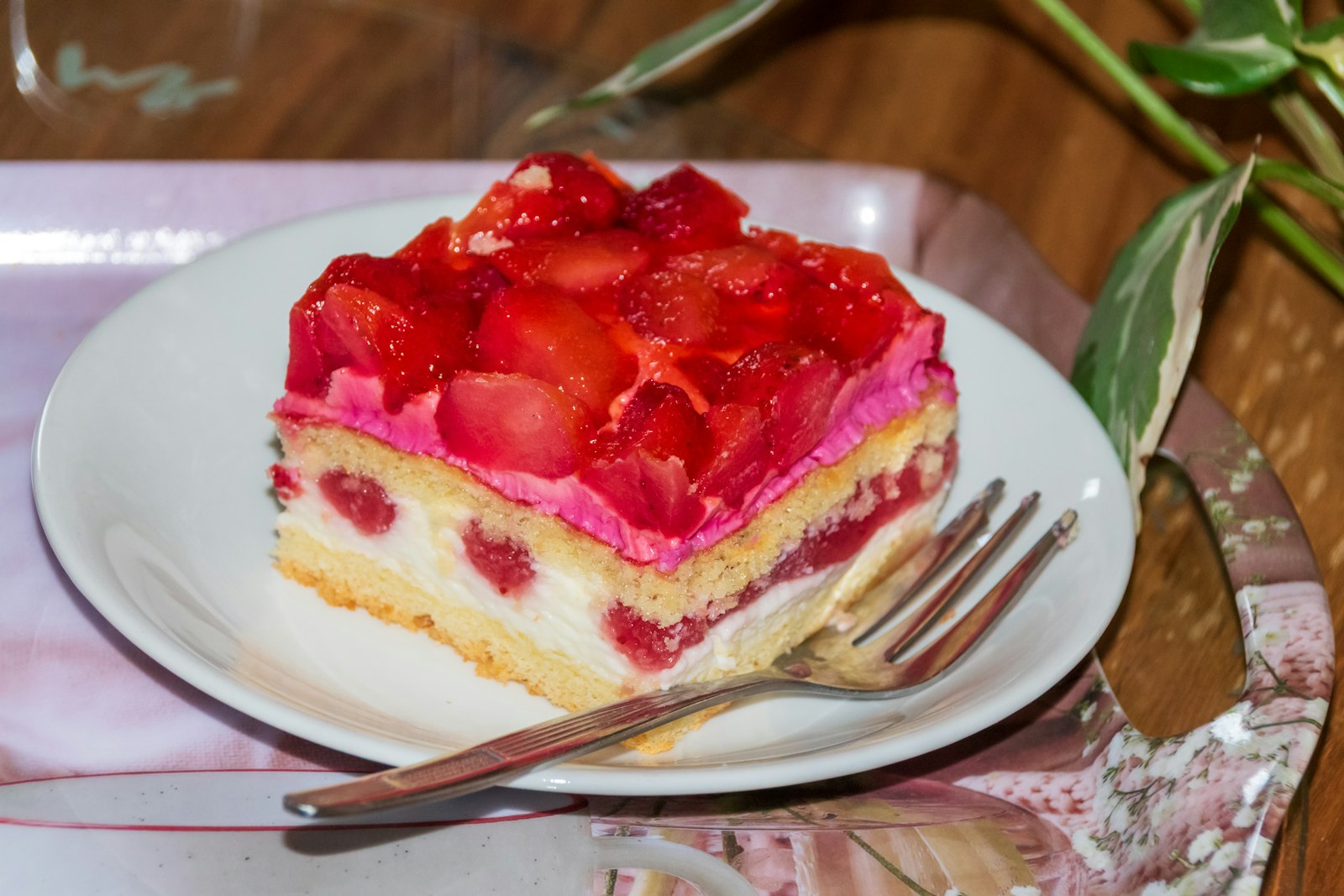 Strawberry cake slice with glazed berries on top