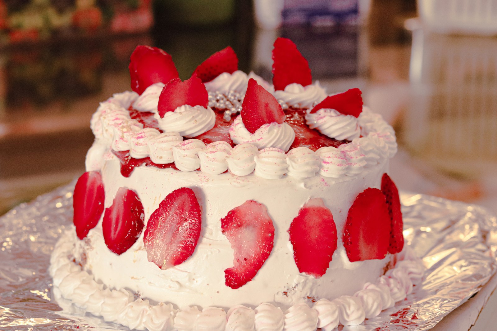 Strawberry cake topped with fresh strawberries and cream