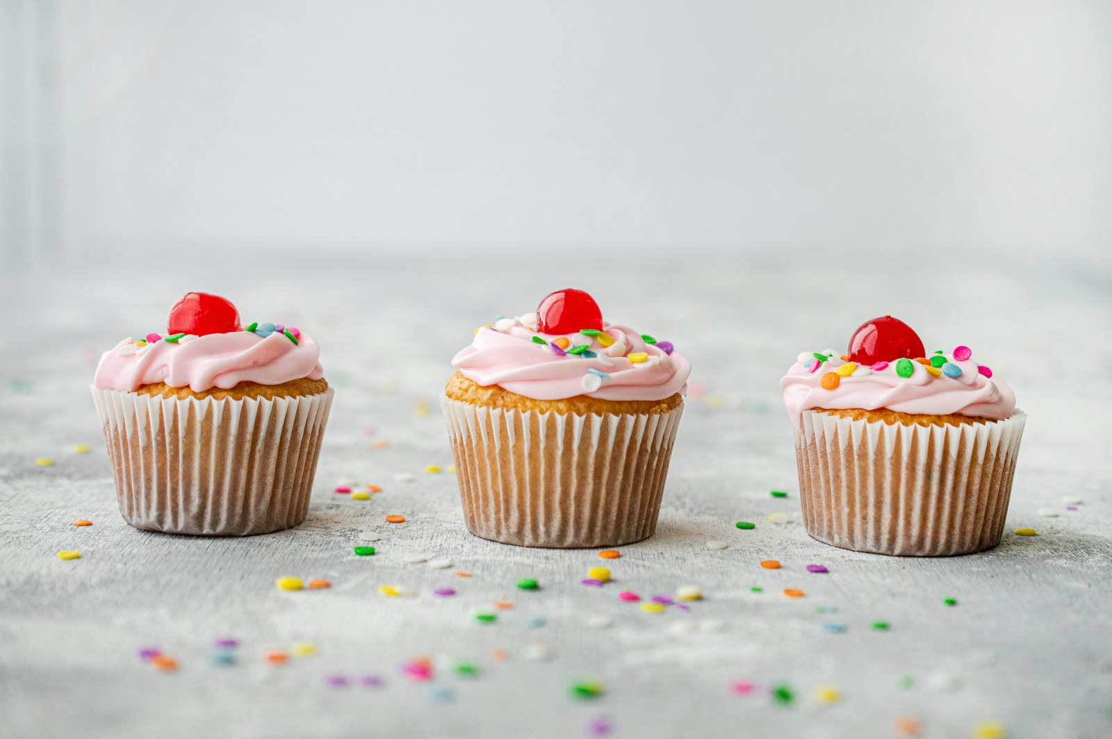 Strawberry frosted mini cakes with sprinkles