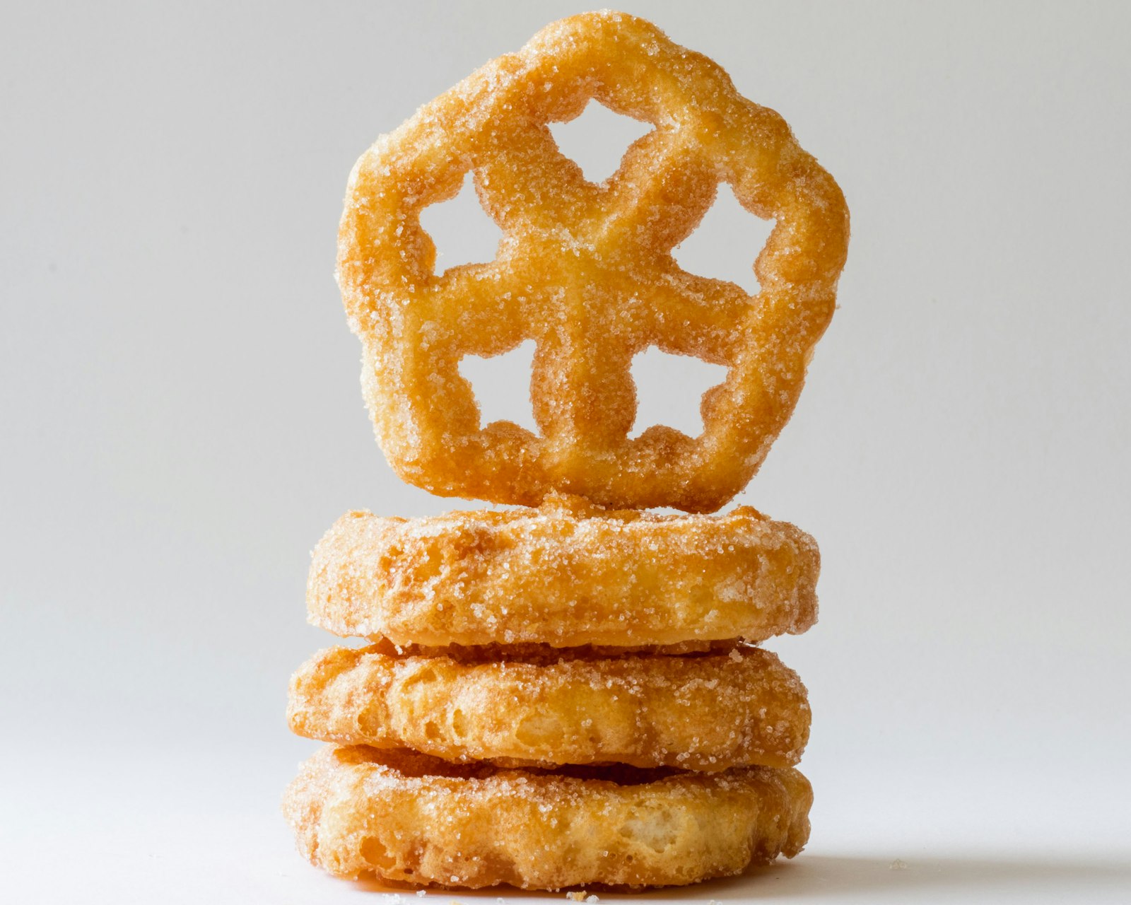 Crispy fried bunuelos stacked on a plate