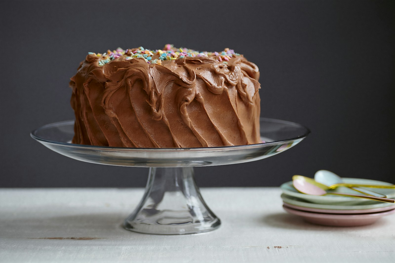 Chocolate frosted layer dessert on a glass stand