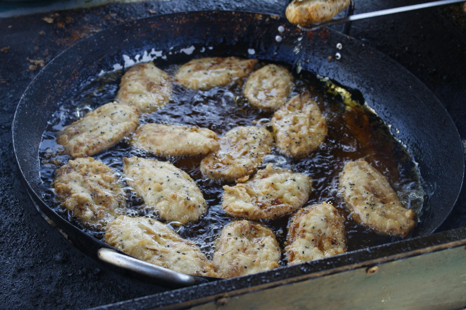 Crispy banana fritters frying in a pan, easy banana desserts