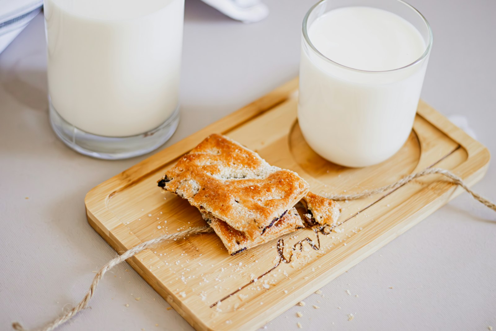 Squares of crispy filo custard pie with glasses of milk