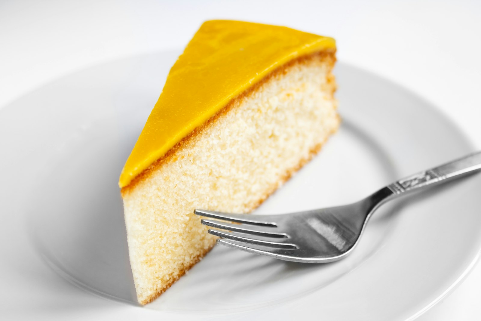 Slice of glazed orange cake with a fork