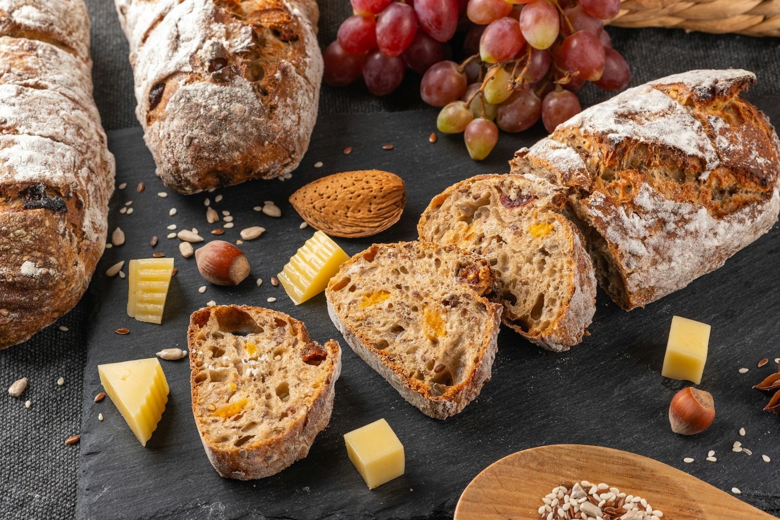 Sliced cheese bread loaf with grapes and cheese cubes